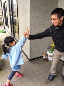 女の子とお父さんが右手でタッチをしている写真