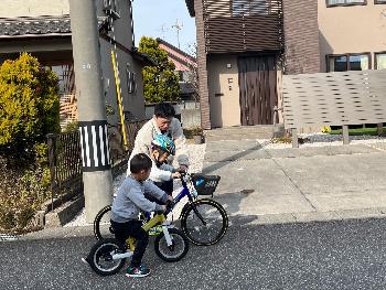 子供達に自転車の乗り方を教えてあげるお父さん