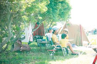 お父さんと子供たちが自然の中で会話を楽しんでいる