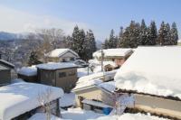 高台から見える住宅の屋根に大雪が積もっている様子の写真