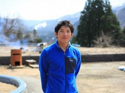 青いシャツを着て笑顔で写っている松田 好弘さんの写真