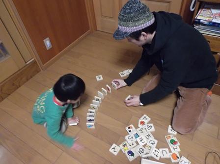男の子と一緒にドミノで遊んでいるお父さんの写真