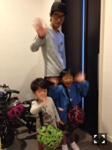 お父さんと男の子2人が手を振っている写真