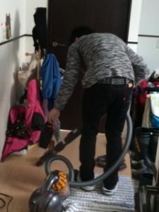 掃除機をかけているお父さんの後ろ姿の写真