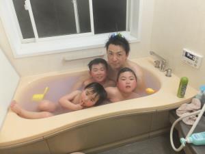 子供3人と一緒に湯船に浸かっているお父さんの写真