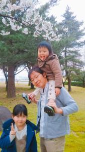 お父さんの左横に女の子が立ち、もう1人の子を肩車しているお父さんの写真