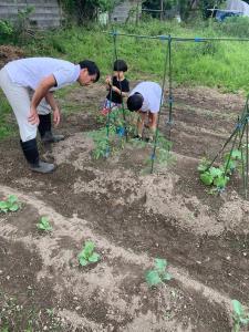 子供達と一緒に畑作業をしているお父さんの写真