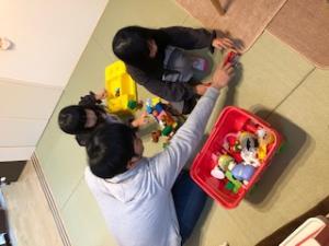 和室で子供二人と遊んでいるお父さんの写真