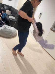 女の子の両手を持ってクルクルと回っているお父さんの写真
