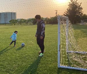 子どもとサッカーを楽しむお父さん