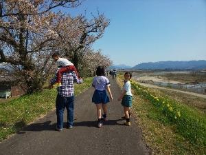 息子を肩車し、家族で散歩を楽しむお父さん