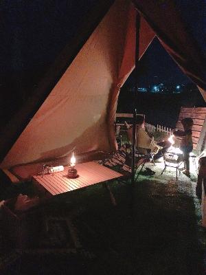 子ども達と庭でキャンプをするお父さん（夜の光景）