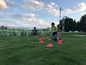 庭でサッカーをするお父さんの女の子