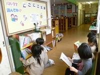 本棚の前で本を選んでいる子供達と、椅子に座り本を読んでいる子供達の写真