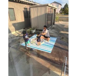 子どもたちと一緒に水遊びをしているパパ