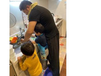 子ども達と一緒にお米をといでいるお父さん