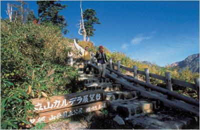 立山カルデラ展望台に続く石の階段を下りている2人の写真